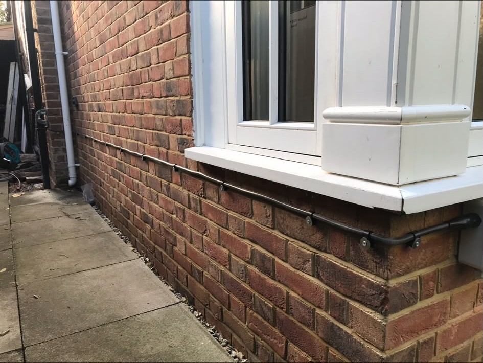 Weatherproof external cable enclosure fitted below a window