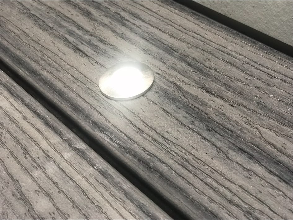 Close-up of a recessed deck light installed flush into decking