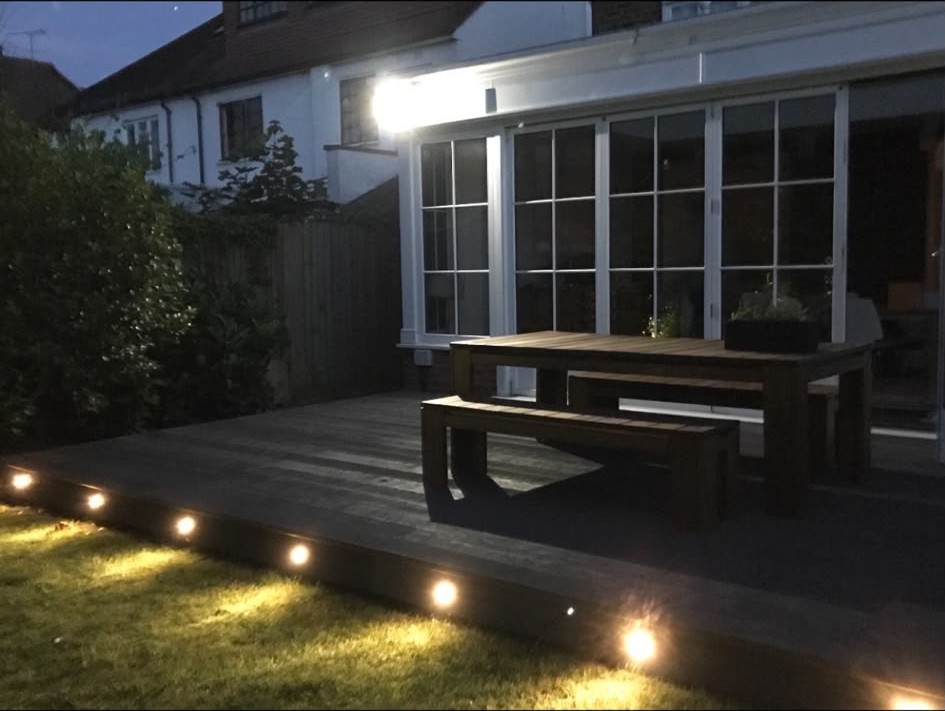Decking and garden lighting installed outside a house at dusk