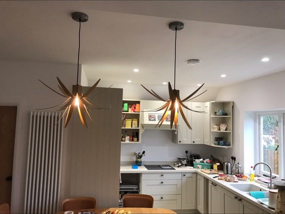 Decorative pendant lights hung and wired over a kitchen dining area