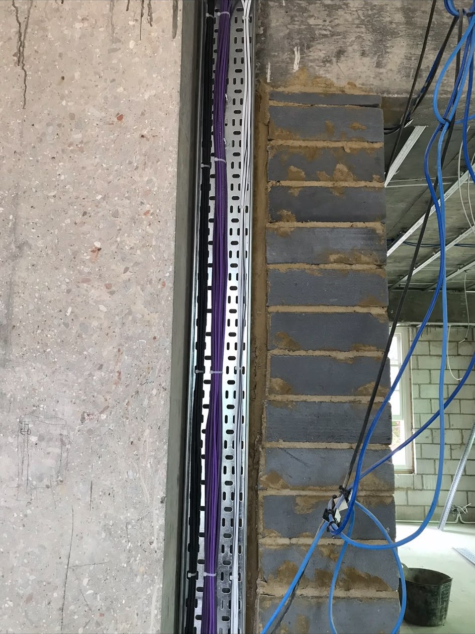 Commercial first fix wiring run in cable tray through a concrete-framed unit