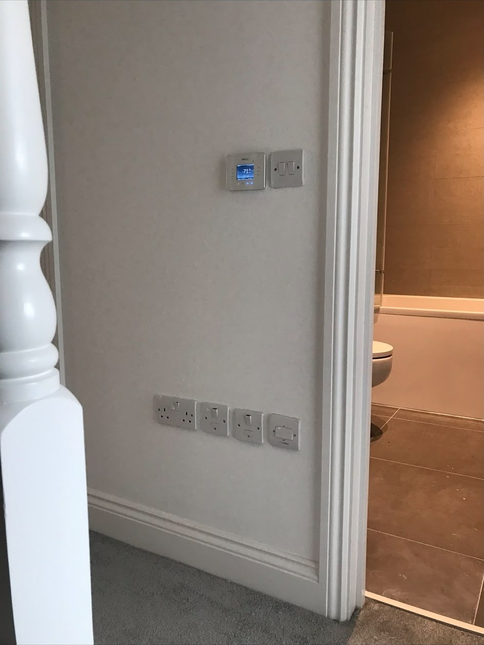 New double sockets and switch plates installed on a finished wall