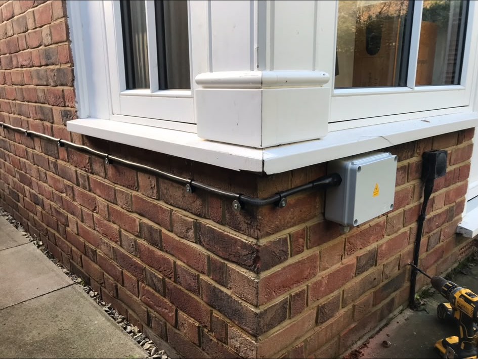 Exterior isolator and cable run installed on a house wall
