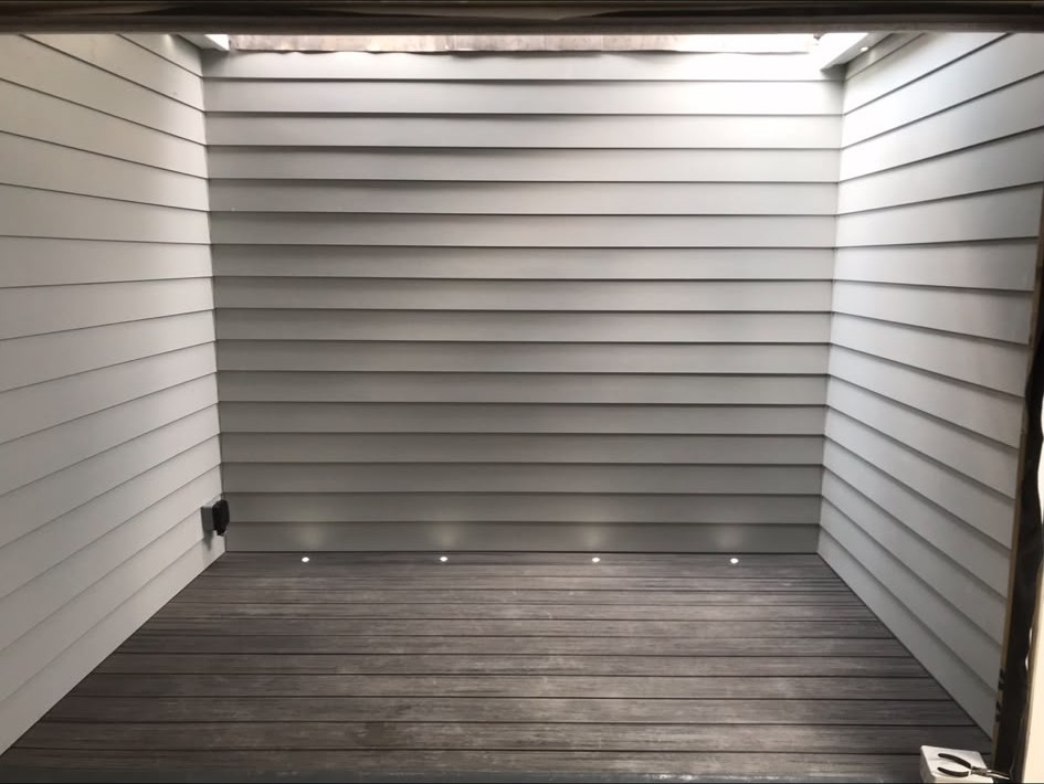 Recessed lighting installed under a clad canopy over a decked area